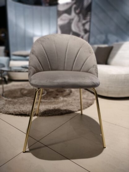 Krzesło tapicerowane z przeszyciami na oparciu na złotych nogach